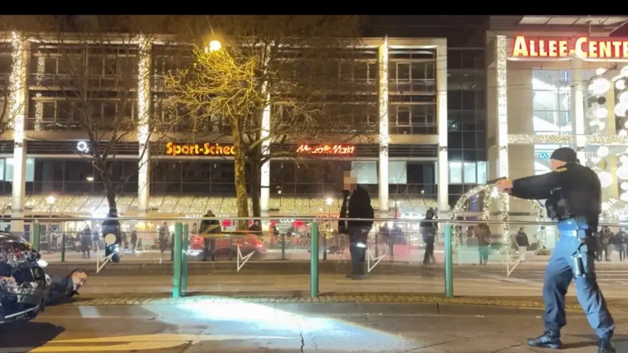 Esta foto muestra al perpetrador (50, izquierda) tirado en el suelo. A pocos metros hay un polic&iacute;a con el arma en la mano. El fald&oacute;n delantero del coche est&aacute; muy da&ntilde;ado.