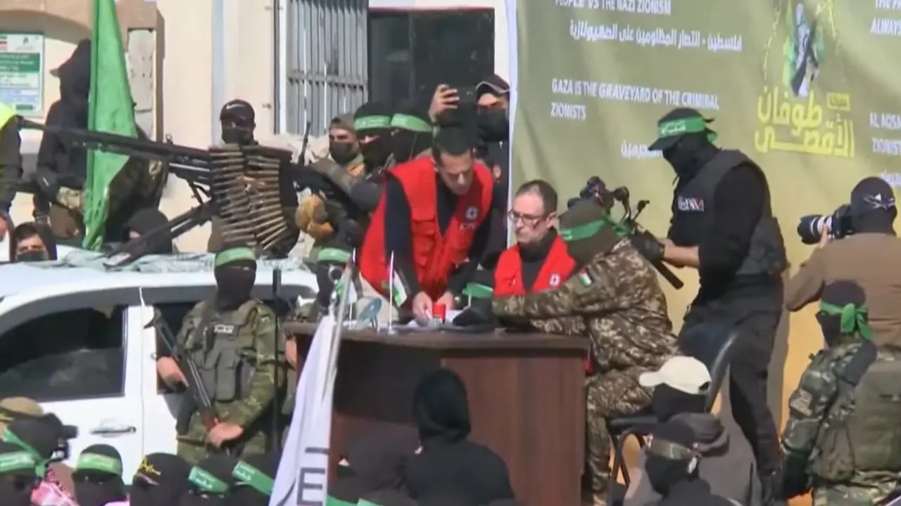 Milicianos de Ham&aacute;s junto a representantes de la Cruz Roja Internacional durante el proceso de entrega de rehenes israel&iacute;es en la Franja de Gaza. La escena, marcada por una exhibici&oacute;n militar y propagand&iacute;stica, ha generado fuertes cr&iacute;ticas por el uso pol&iacute;tico del intercambio.