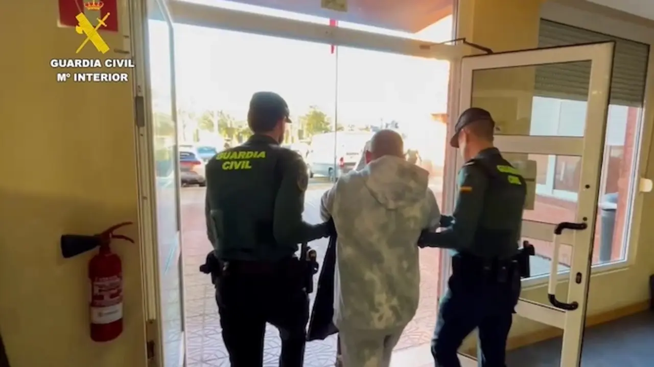 Momento en que agentes de la Guardia Civil escoltan a uno de los detenidos durante la operaci&oacute;n "GADUS".