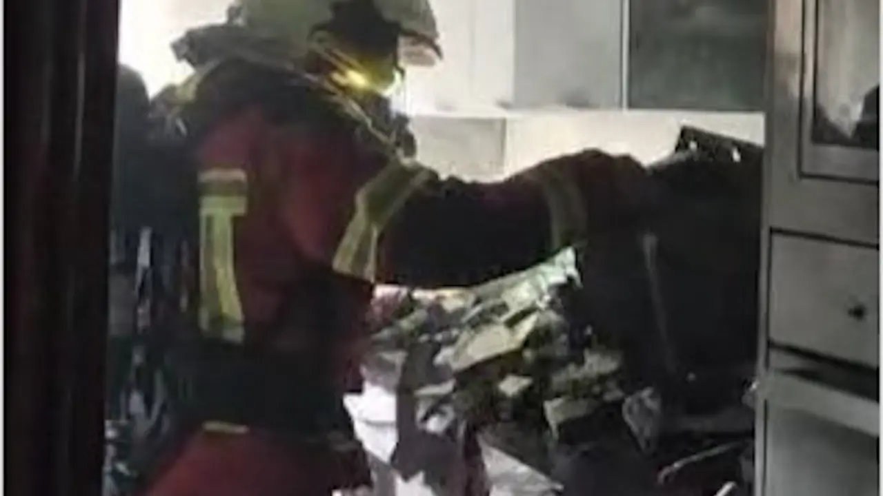 Uno de los bomberos en la casa incendiada. / 112