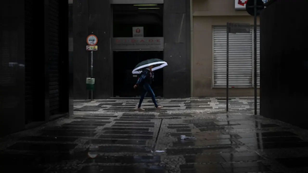 Una persona va co un paraguas por la calle. / A.E
