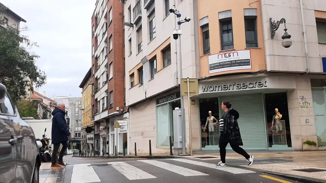 Peatones cruzan la confluencia de las calles Consolaci&oacute;n y Joaqu&iacute;n Hoyos, bajo la vigilancia de las c&aacute;maras pol&eacute;micas instaladas por el Ayuntamiento de Torrelavega. / S.D.