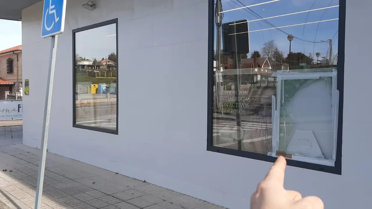 : Ventana destrozada de la farmacia de Mogro tras el robo ocurrido en la madrugada del mi&eacute;rcoles. Los ladrones rompieron el cristal para acceder al interior. / S.D.