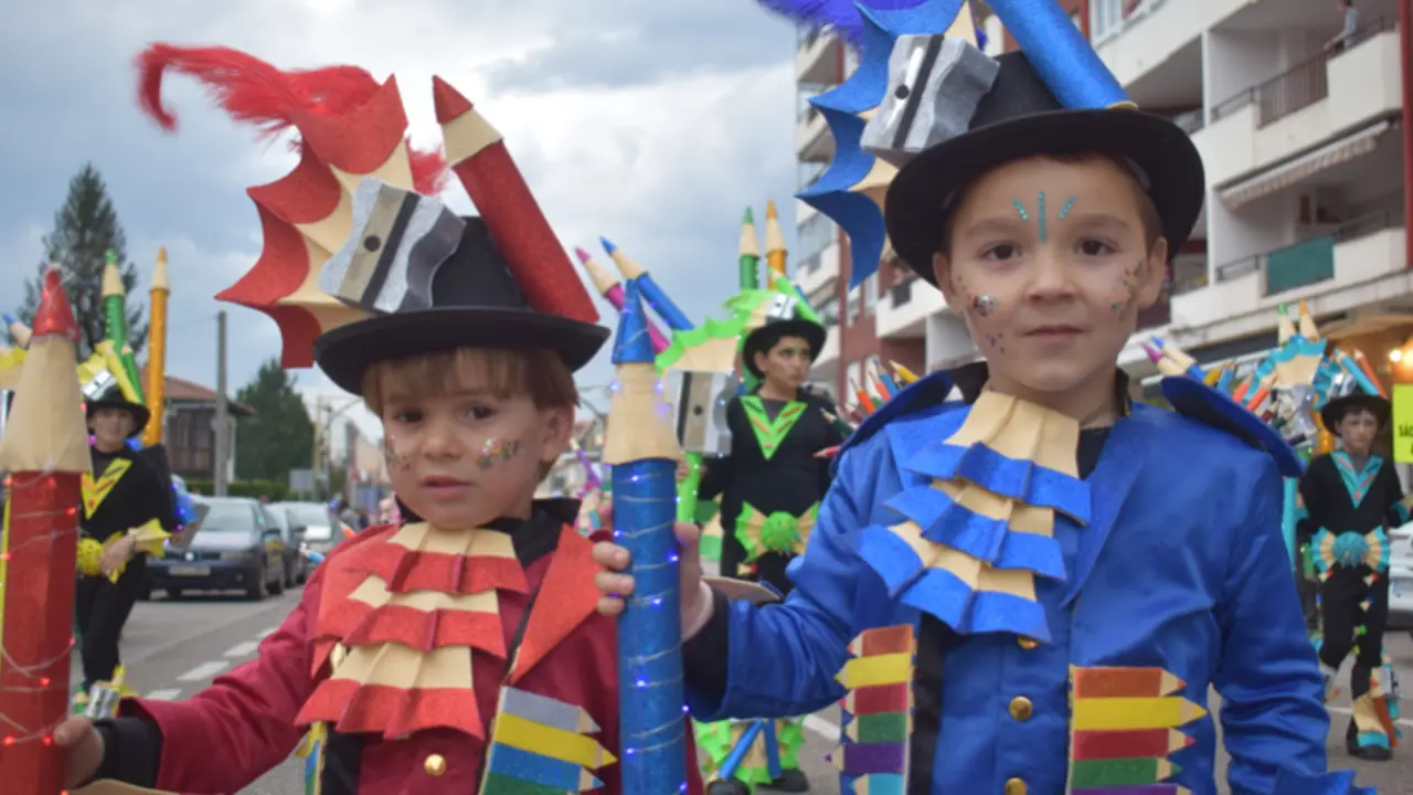 Peque&ntilde;os artistas del carnaval . Dos ni&ntilde;os, con coloridos disfraces inspirados en material de papeler&iacute;a, se desfilan con entusiasmo durante el Carnaval Infantil 2025 de Pi&eacute;lagos , un evento lleno de creatividad y alegr&iacute;a que ha reunido a familias y vecinos en una gran celebraci&oacute;n.