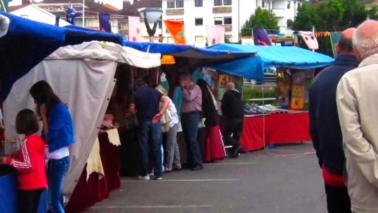 Varias personas en el mercadillo de Cartes. / EP
