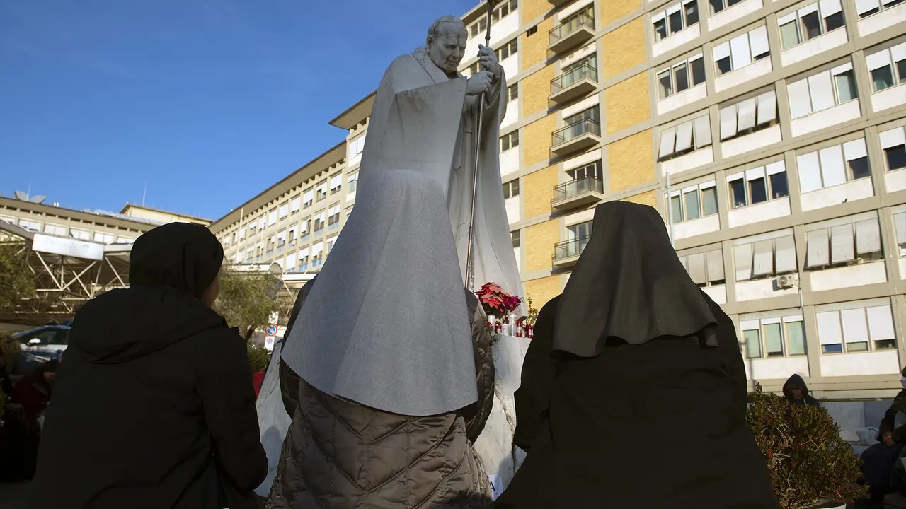 Varias personas rezan frente al hospital donde se encuentra ingresado el papa Francisco. / ALESSIA GIULIANI