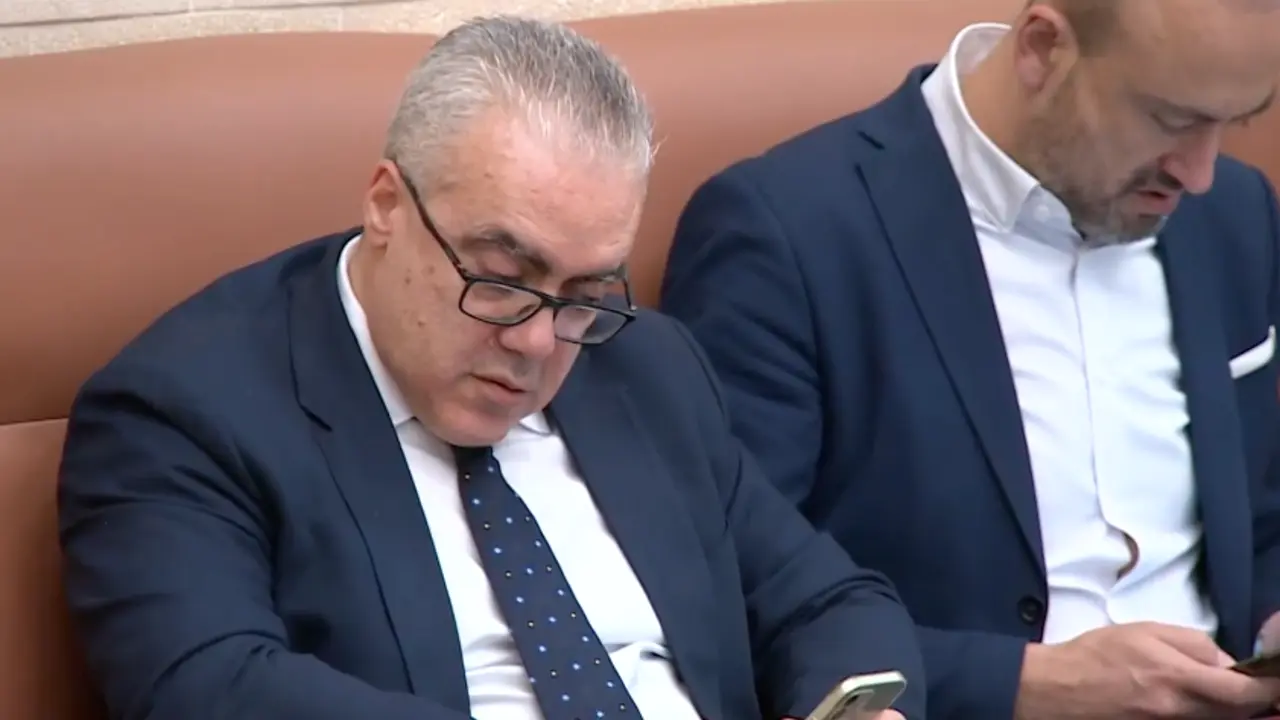 Pedro Hernando y Javier L&oacute;pez consultan sus tel&eacute;fonos durante una sesi&oacute;n en el Parlamento.