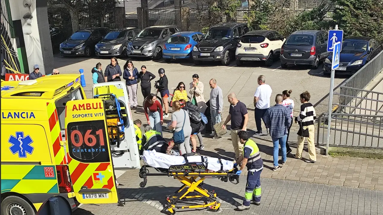 Los servicios de emergencias atienden a la v&iacute;ctima tras un brutal apu&ntilde;alamiento en plena v&iacute;a p&uacute;blica, mientras los testigos observan con preocupaci&oacute;n. La ambulancia del 061 de Cantabria se encuentra en el lugar para trasladar al herido con urgencia.