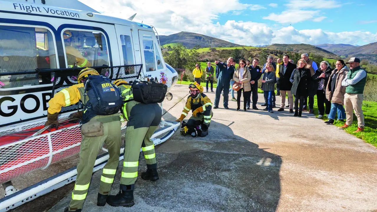 Miembros de la Brigada de Refuerzo en Incendios Forestales realizando una demostraci&oacute;n junto al helic&oacute;ptero. / Alerta