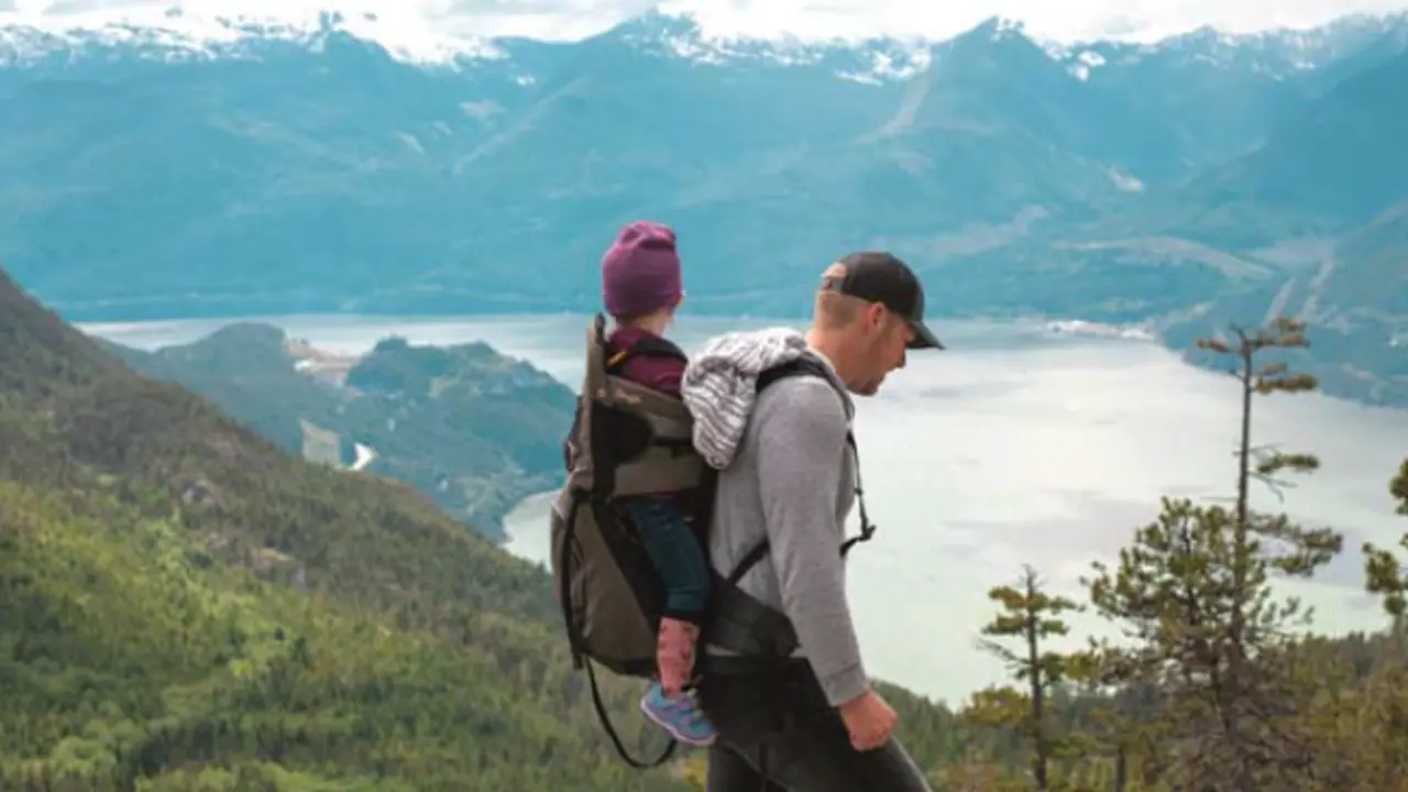 Un padre y su hijo disfrutan de una caminata en la monta&ntilde;a, simbolizando el v&iacute;nculo, la protecci&oacute;n y el acompa&ntilde;amiento que representa la paternidad.