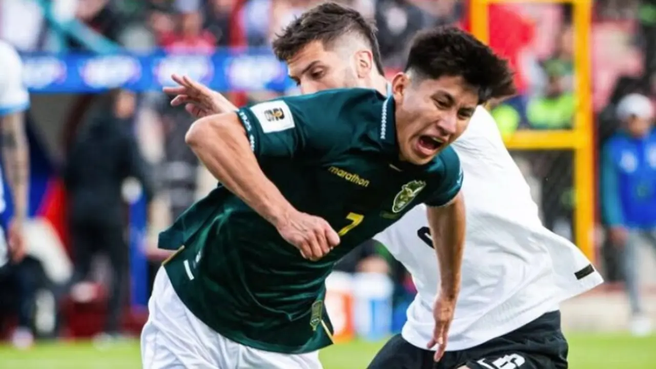Un jugador de Bolivia lucha por el bal&oacute;n en un intenso duelo ante Uruguay en La Paz, durante una jornada clave de las Eliminatorias Sudamericanas rumbo al Mundial 2026.