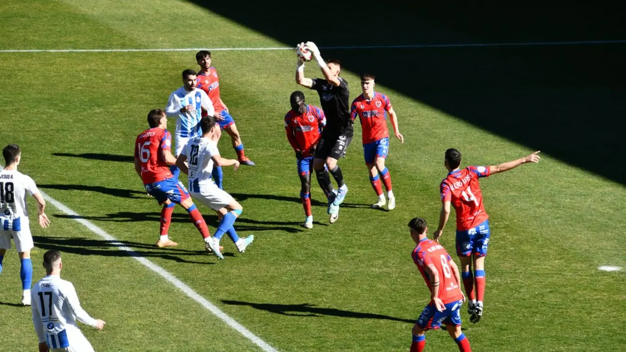 El portero del Numancia despeja un bal&oacute;n a&eacute;reo ante varios jugadores de la Gimn&aacute;stica durante un partido que sentenci&oacute; a&uacute;n m&aacute;s el futuro del conjunto torrelaveguense. / X