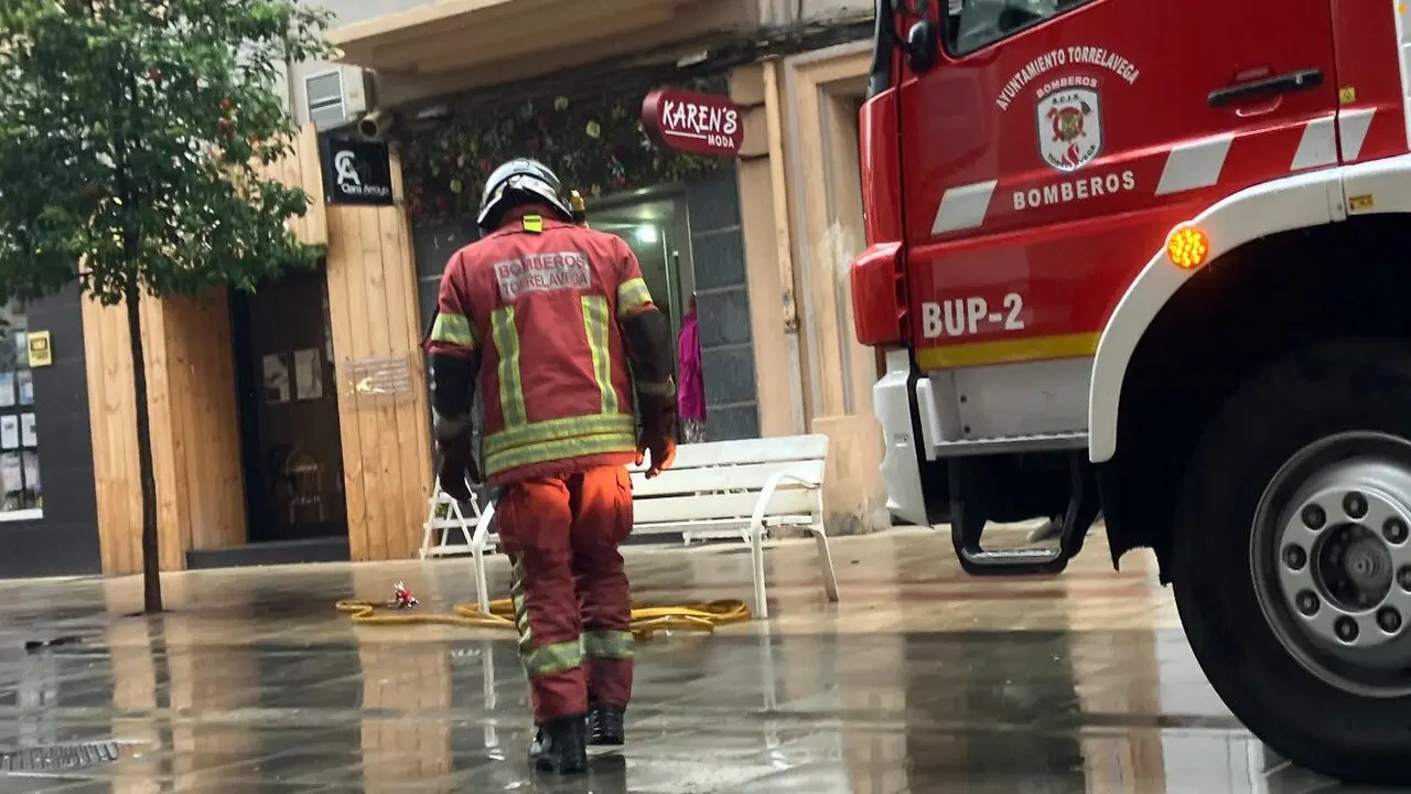 Un bombero durante un servicio en la calle Consolaci&oacute;n de Torrelavega. / S.D.