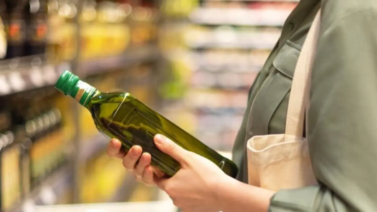 Una mujer comprando aceite de oliva. / A.E