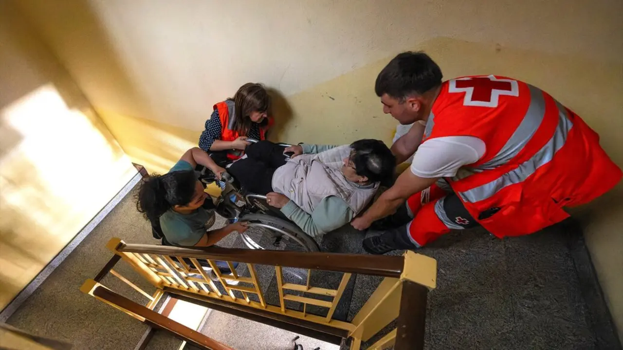 Efectivos de emergencias ayudan a una mujer a subir las escaleras durante el apag&oacute;n. / Tom&aacute;s Alonso
