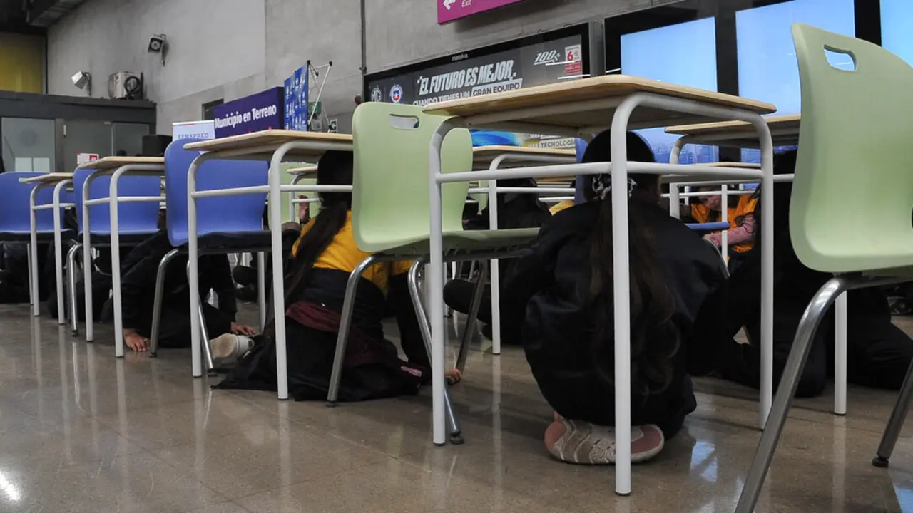 Varios ni&ntilde;os se refugian bajo las mesas durante un terremoto en Chile. / Victor Huenante