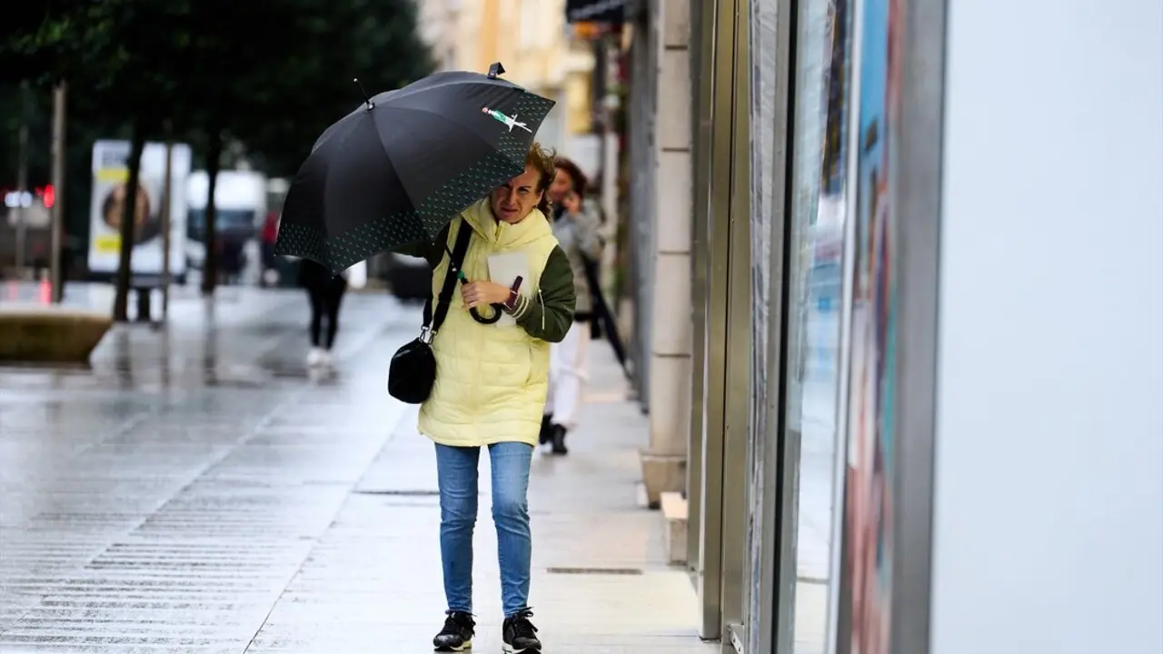 Una persona se cubre de la lluvia y el viento con paraguas. / Juanma Serrano