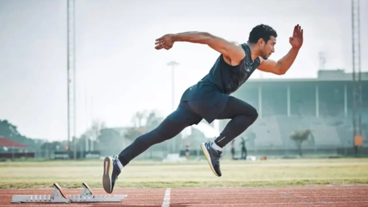 Un atleta inicia una carrera de velocidad en la pista, reflejando el compromiso, la preparaci&oacute;n f&iacute;sica y el uso estrat&eacute;gico de herramientas avanzadas para mejorar el rendimiento deportivo.