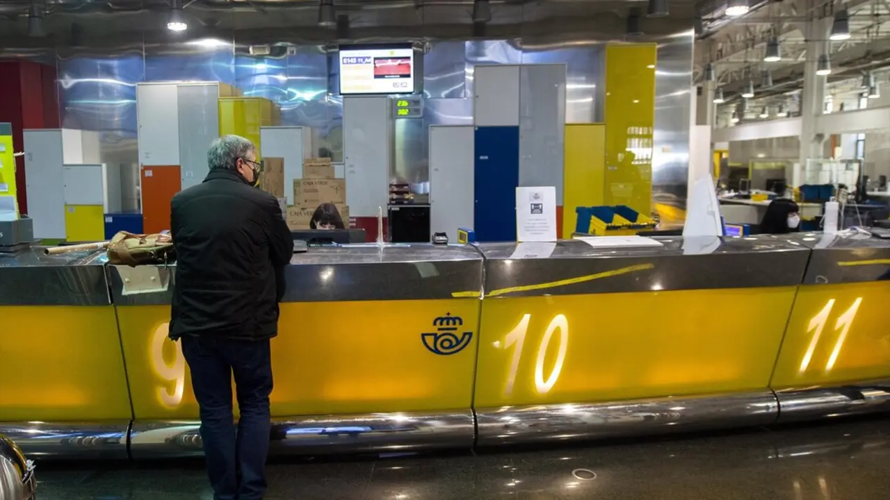 Un cliente es atendiendo en la Oficina de Correos de Cibeles, en Madrid. / Alberto Ortega