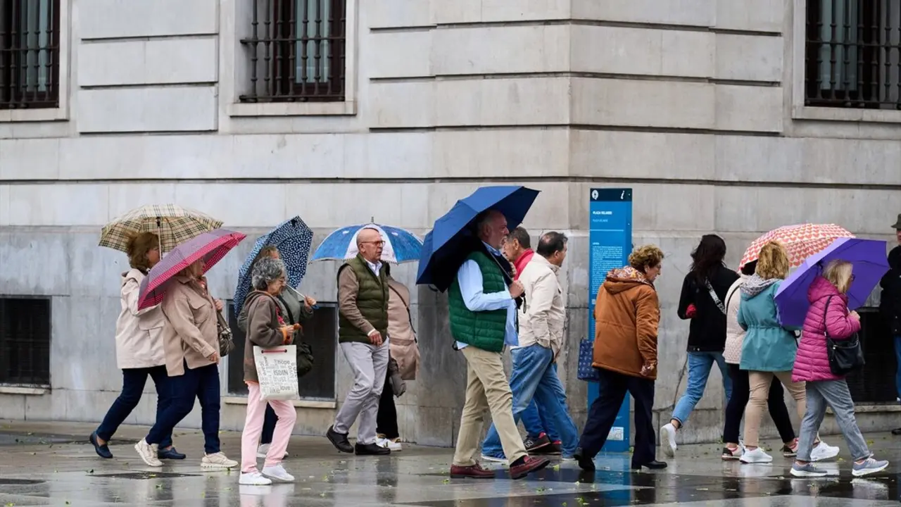 Varias personas se cubren de la lluvia y el viento con paraguas. / Juanma Serrano
