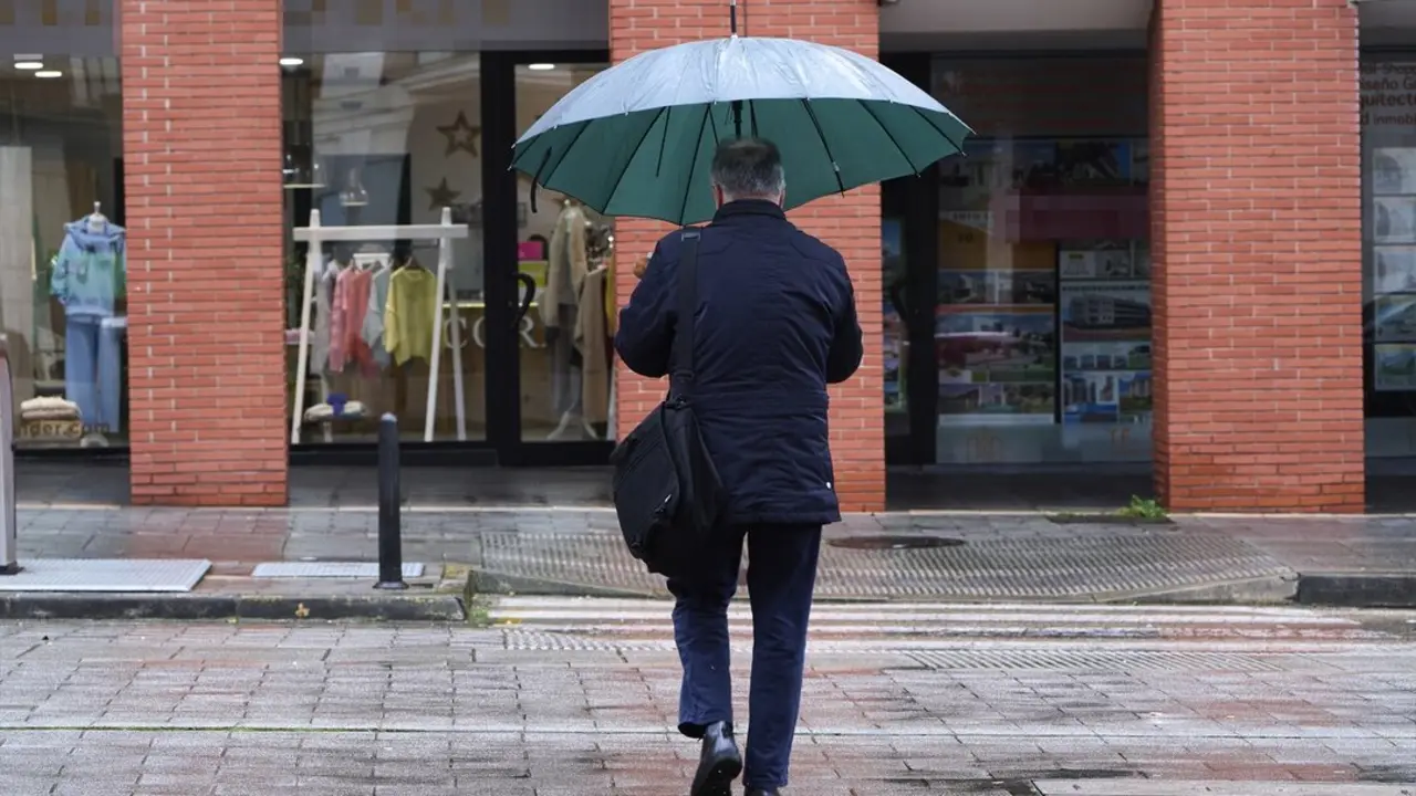 Una persona paseando con un paraguas por Santander. / C&eacute;sar Ortiz