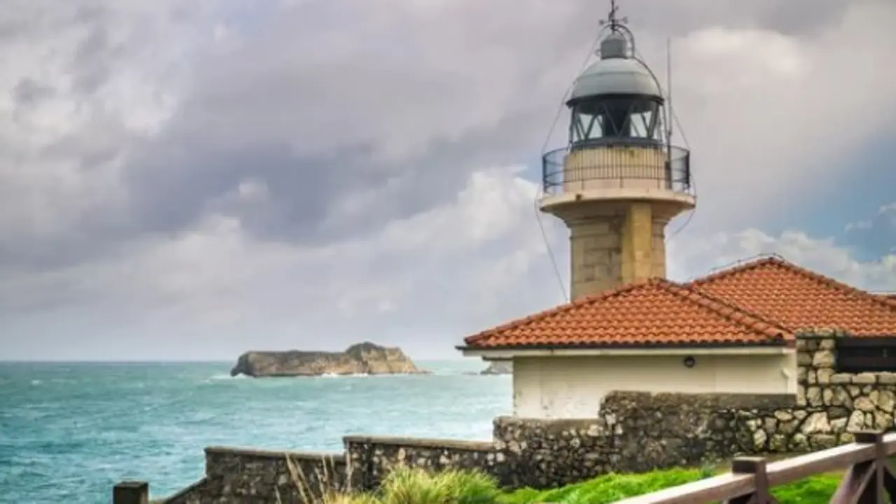 El faro de Suances con la Isla de los Conejos al fondo. / A.S.