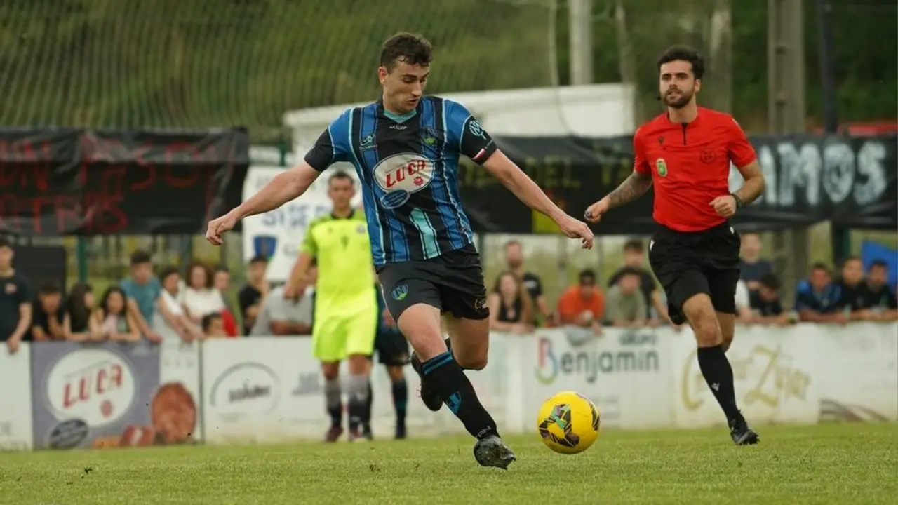 Un jugador del Monta&ntilde;as del Pas conduce el bal&oacute;n en una acci&oacute;n del partido decisivo por el ascenso a Tercera Federaci&oacute;n, bajo la atenta mirada del colegiado.