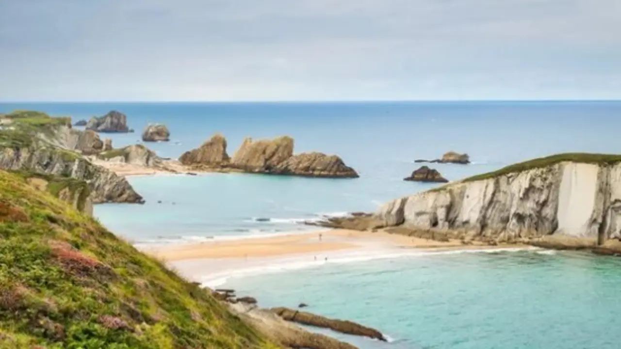 T&oacute;mbolo de arena que une la isla del Castro con la costa quebrada de Cantabria durante la marea baja. / A.S.