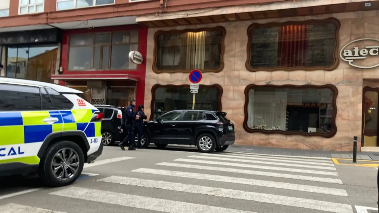 Dos polic&iacute;as locales de Torrelavega se disponen a sancionar a un veh&iacute;culo estacionado, dejando la multa en el parabrisas, en el &aacute;rea prevista para la futura Zona de Bajas Emisiones.