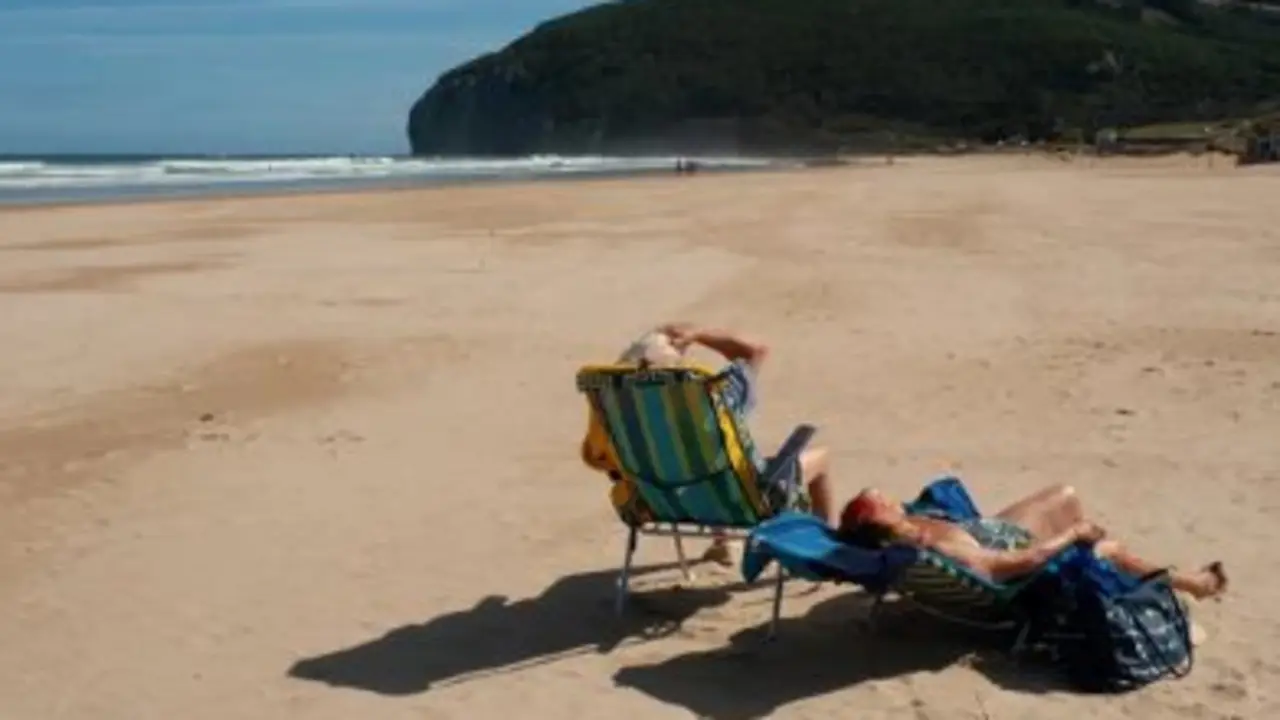 Dos personas disfrutan de un d&iacute;a de sol en la playa. / A.S.