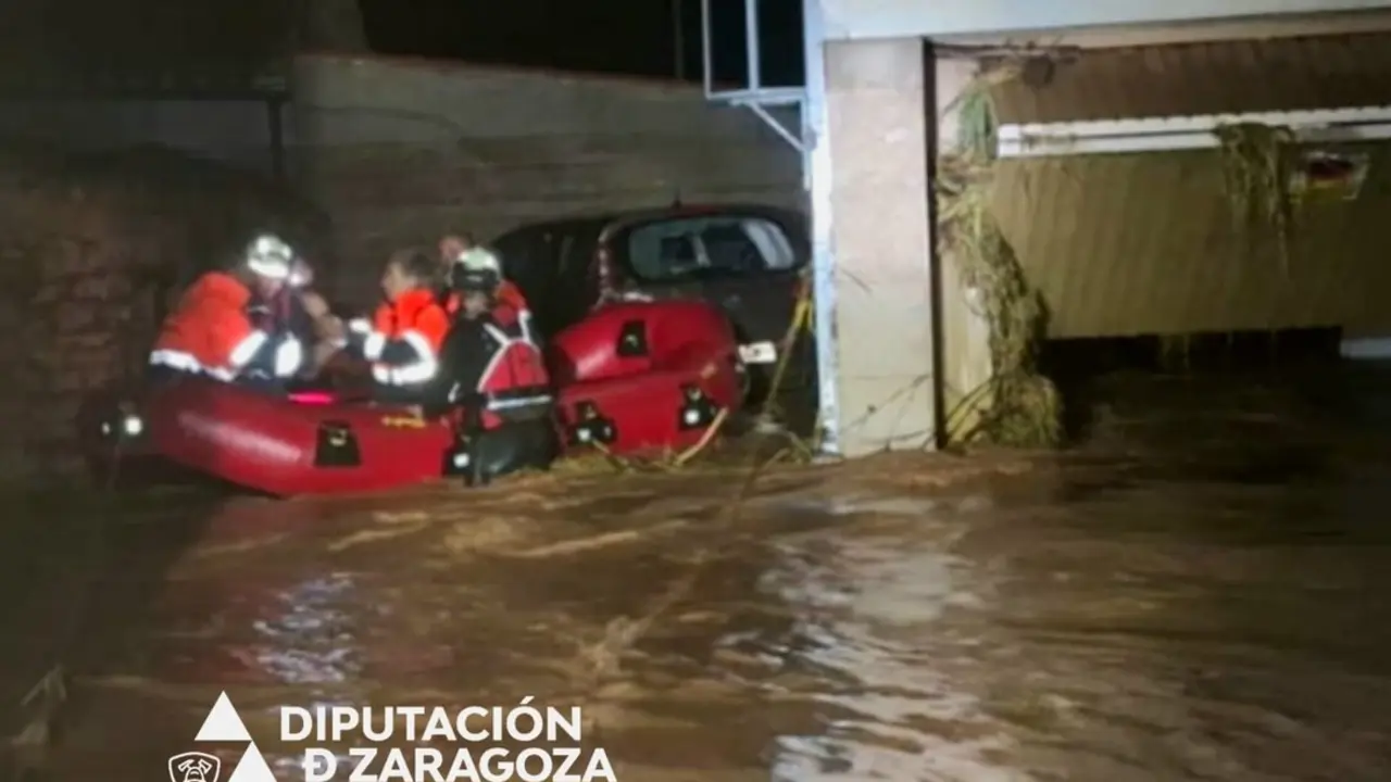 Bomberos de la Diputaci&oacute;n de Zaragoza rescatan a ciudadanos con una balsa tras las inundaciones por las fuertes lluvias en Azuara y Letux. / D.Z.