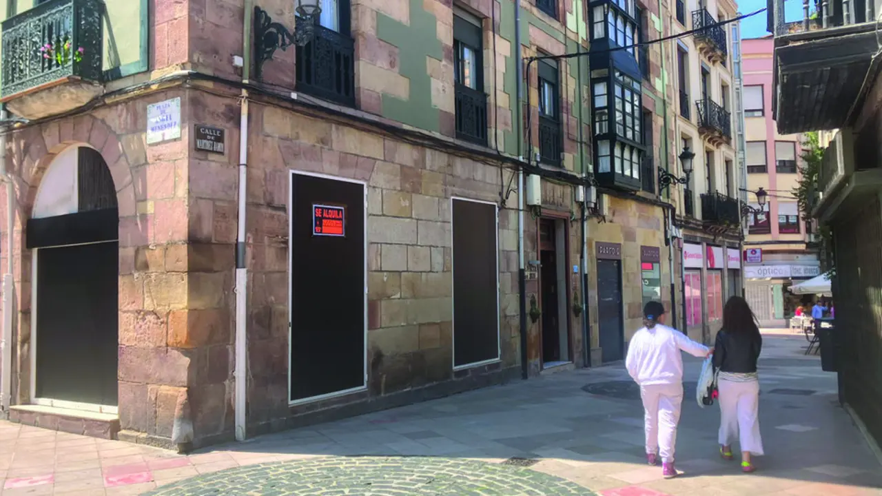 Dos personas pasean frente a un local vac&iacute;o en Torrelavega. / Alerta