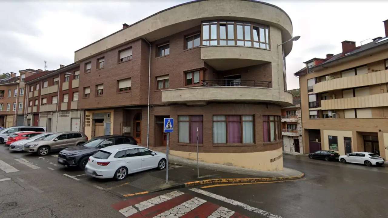 Vista del edificio de la avenida de Rioseco, en Pola de Laviana, donde esta madrugada una mujer de avanzada edad fue asesinada presuntamente por su marido. La Guardia Civil mantiene acordonada la zona mientras prosigue la investigaci&oacute;n.