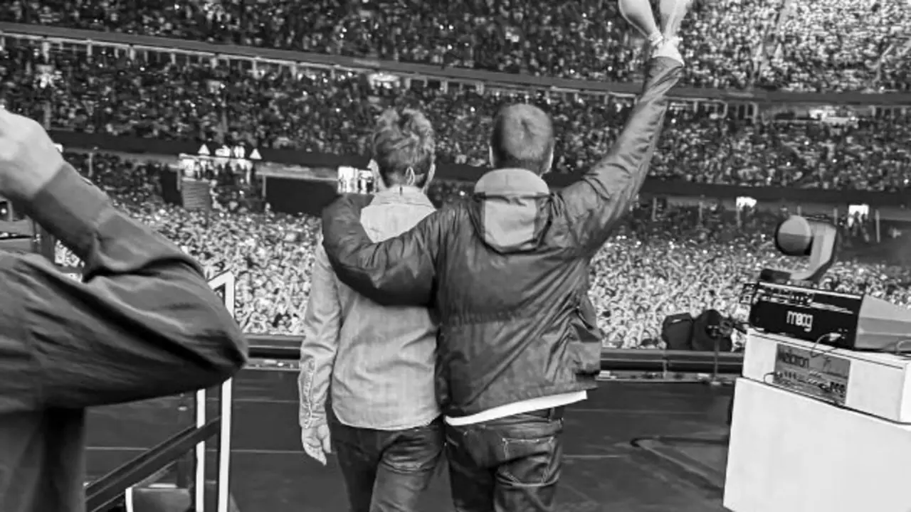 Liam abraza a Noel Gallagher al comienzo del concierto de Oasis. / Oasis