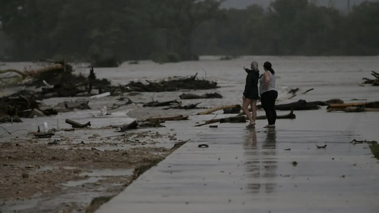 Dos empleados observan el &aacute;rea donde docenas de remolques fueron arrastrados por la crecida de las aguas en el r&iacute;o Guadalupe en Ingram, Texas. / EP