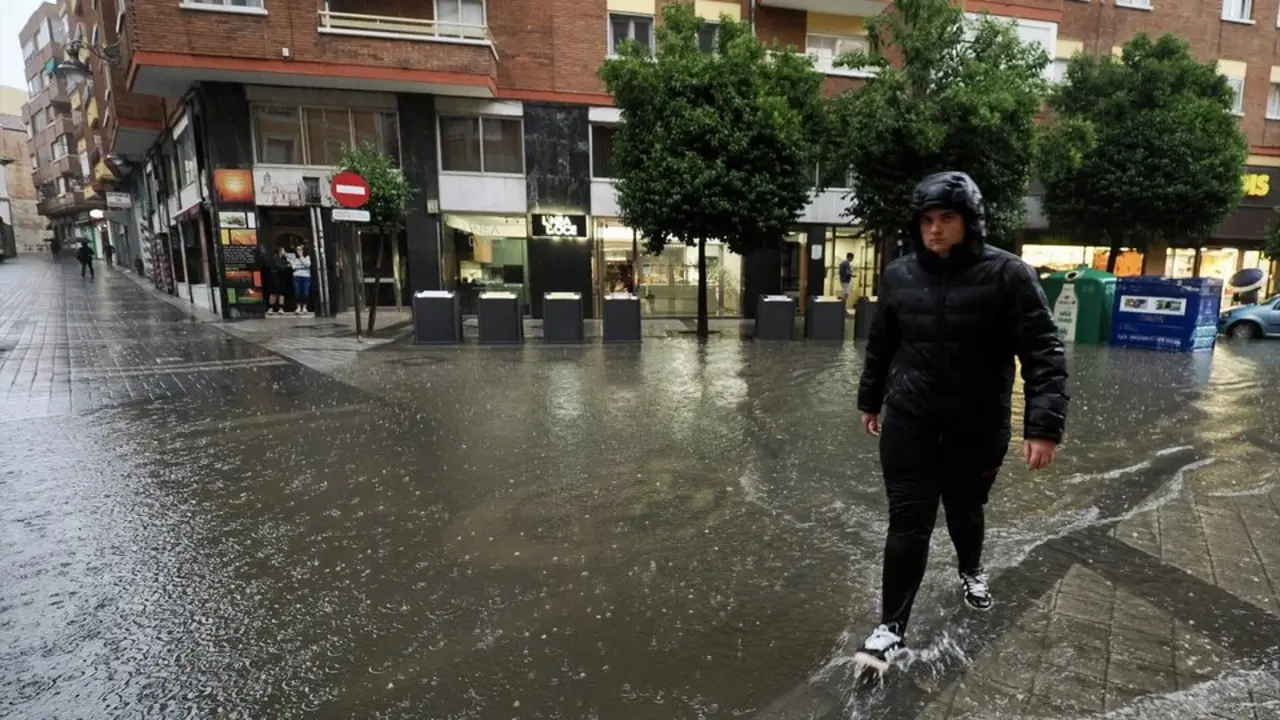 Una persona camina por una calle inundada en Valladolid. / Pablo Requejo