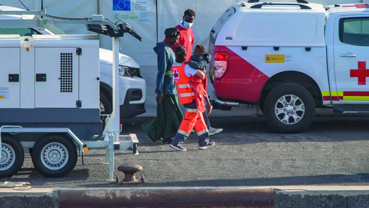 Agentes de los Servicios de Emergencias atienden a una mujer y un menor a su llegada al Puerto de la Restinga, en El Hierro. / Antonio Sempere