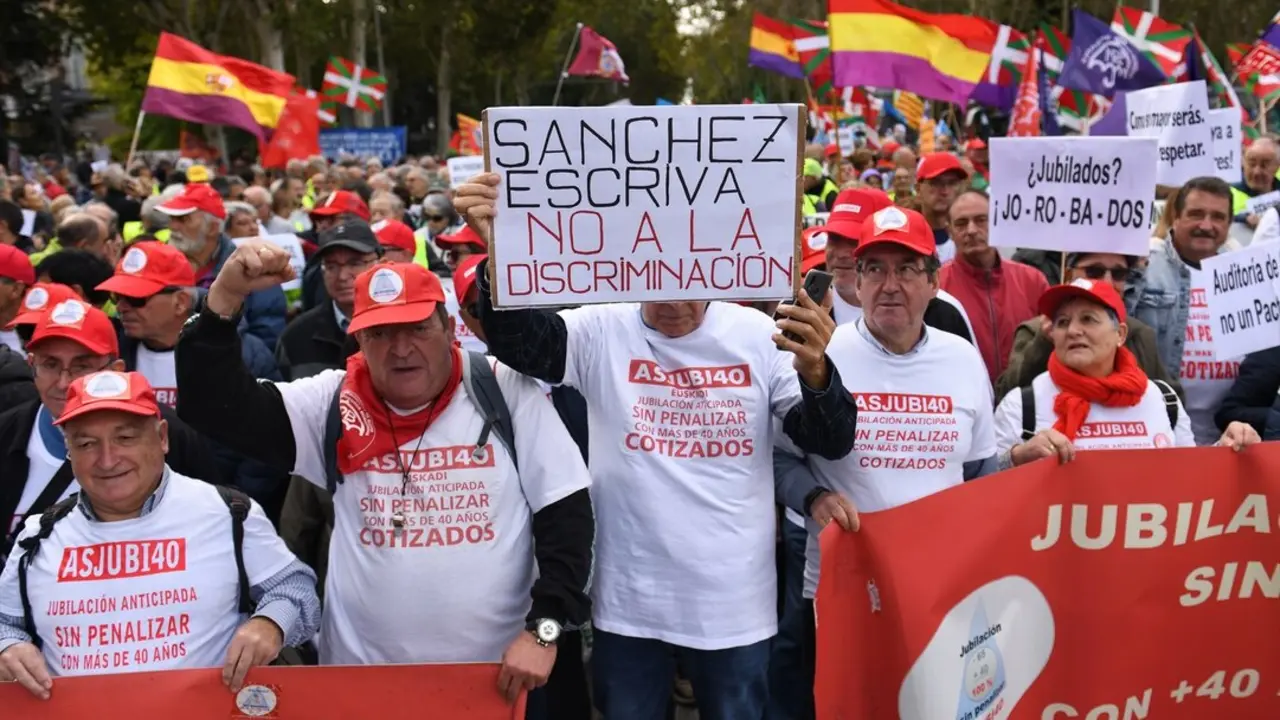 Decenas de personas portan carteles y banderas durante una concentraci&oacute;n de pensionistas. / Fernando S&aacute;nchez