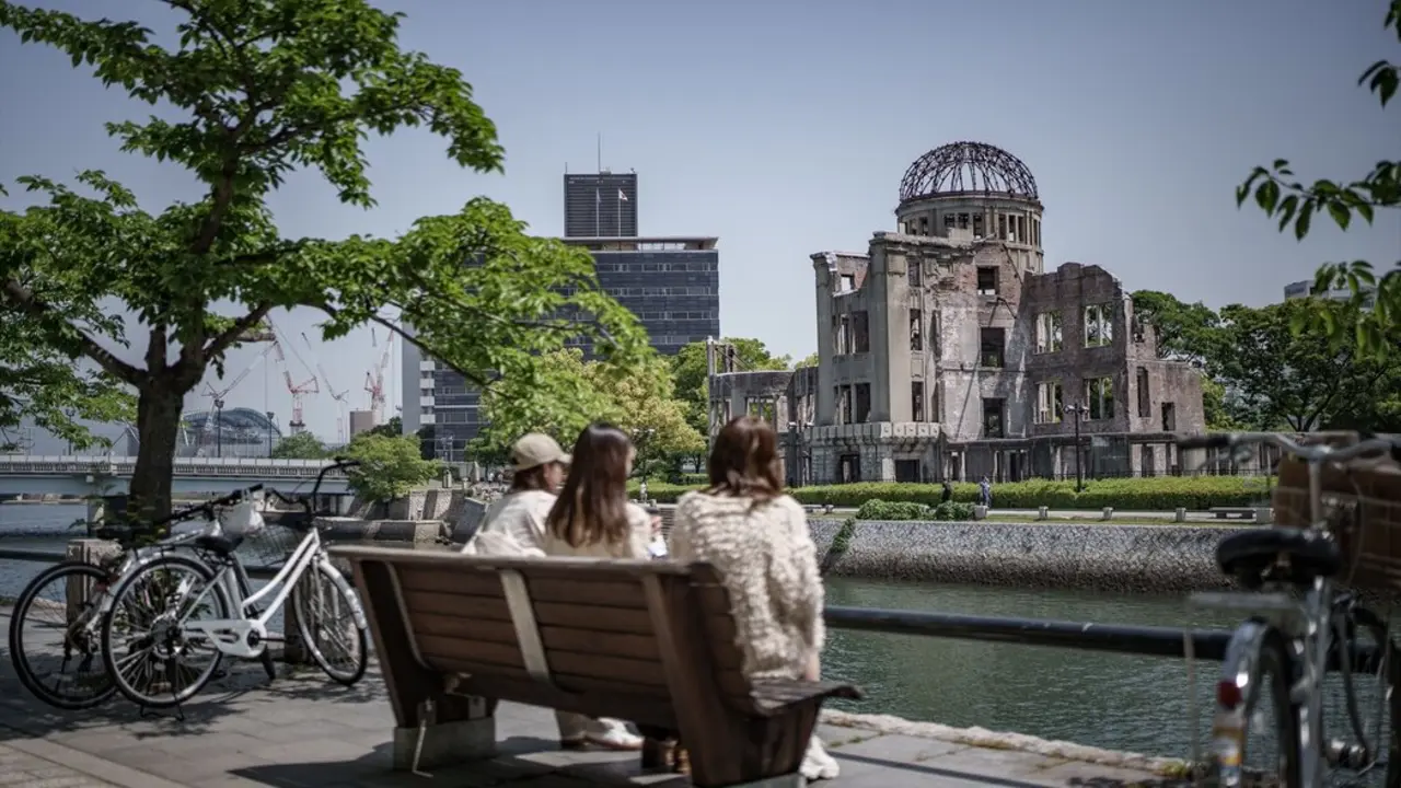 Los transe&uacute;ntes miran hacia la C&uacute;pula Genbaku en el Parque Conmemorativo de la Paz de Hiroshima, sede central de la Cumbre del G7 en Hiroshima. / Michael Kappeler