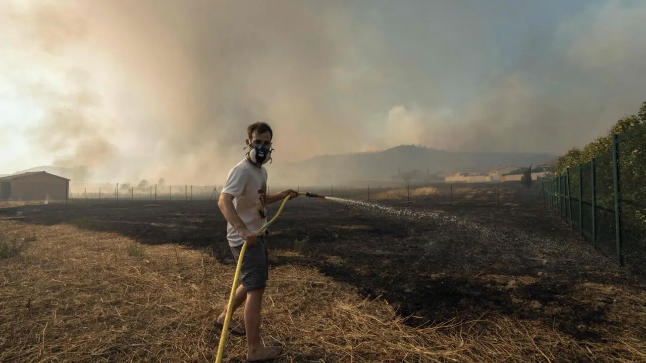 El avance de las llamas ha obligado a evacuar campings y viviendas, dejando a 2.500 hogares sin electricidad y destruyendo casas y veh&iacute;culos. / AFP