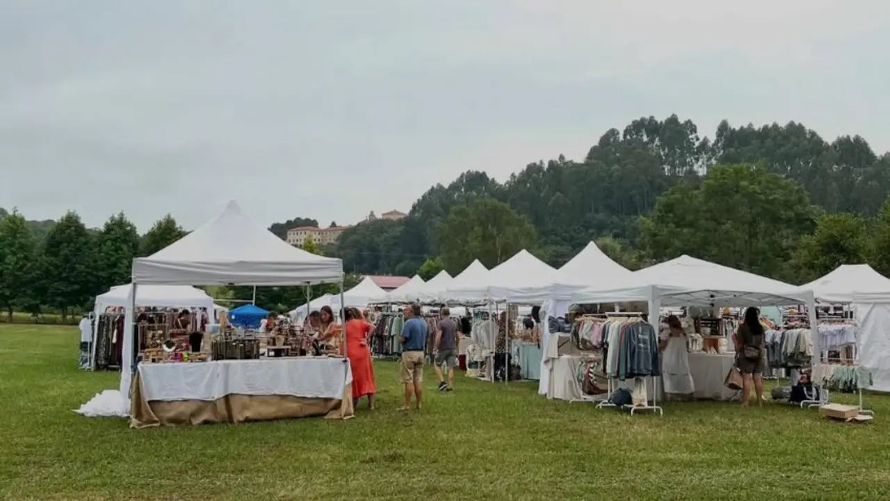 Varias personas disfrutan del mercadillo en Ruiloba. / Popupchic