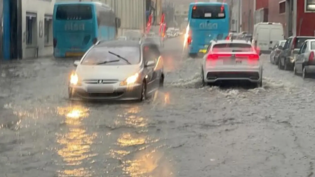 Algunos coches circulando por las calles inundadas de Santander. / x