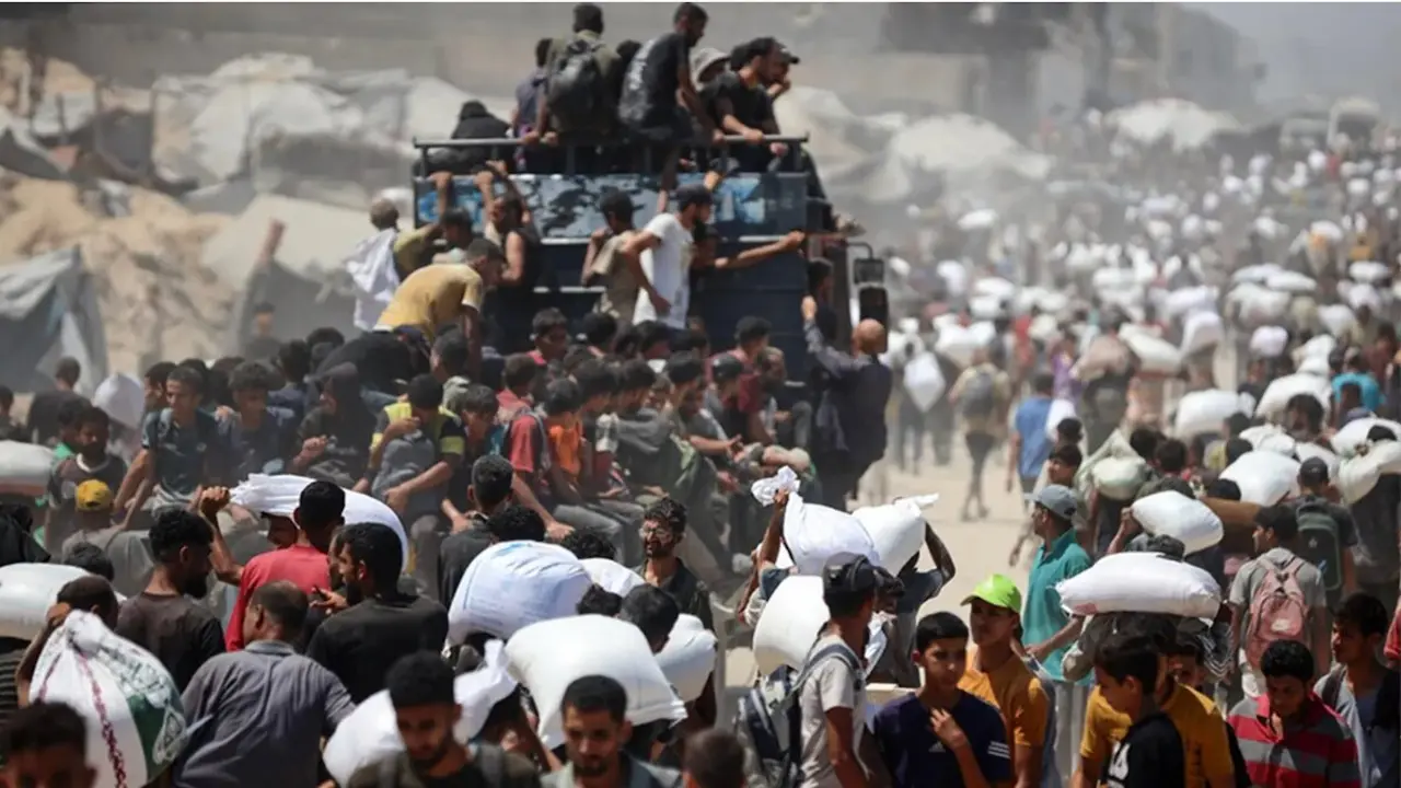 Habitantes de Gaza transportan alimentos lanzados desde el aire por Jordania y los Emiratos &Aacute;rabes Unidos el 27 de julio.