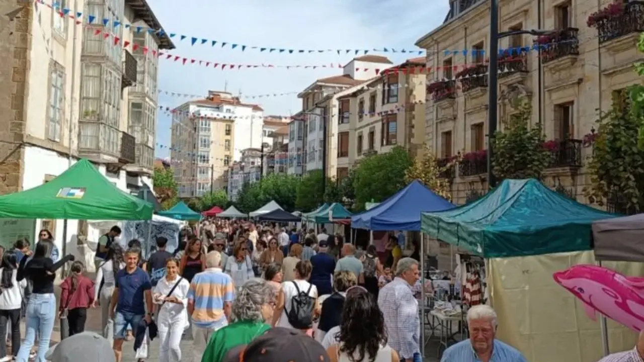 Varias personas pasean por una de las calles de Reinosa en fiestas. / A.R.