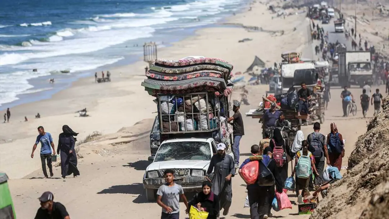 Palestinos con sus pertenencias llegan a un sendero costero al noroeste del campamento de refugiados desde Gaza. / EP