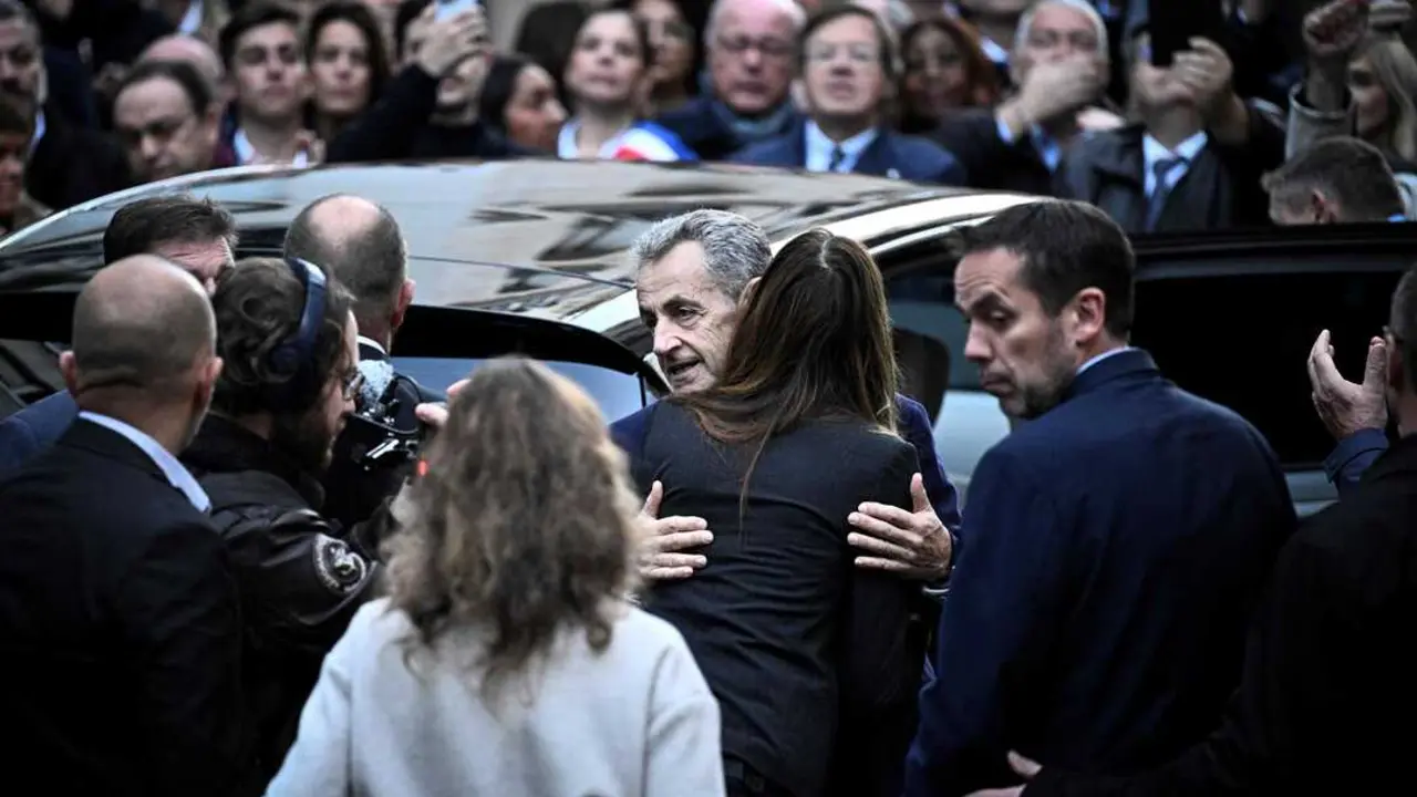 El expresidente franc&eacute;s Nicolas Sarkozy (C) abraza a su esposa Carla Bruni-Sarkozy al salir de su residencia para presentarse en la prisi&oacute;n de La Sante. / EP