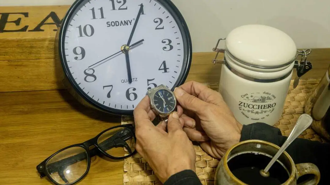 Una persona cambiando la hora en un reloj. / Ricardo Rubio