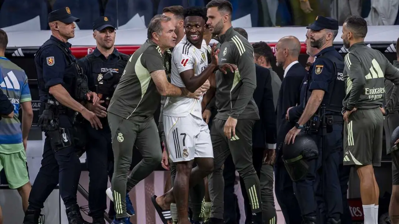 Vinicius Junior, del Real Madrid, es detenido por los asistentes del Real Madrid al final del partido de la Primera Divisi&oacute;n espa&ntilde;ola entre el Real Madrid CF y el FC Barcelona en el Estadio Santiago Bernab&eacute;u. / Alberto Gardin