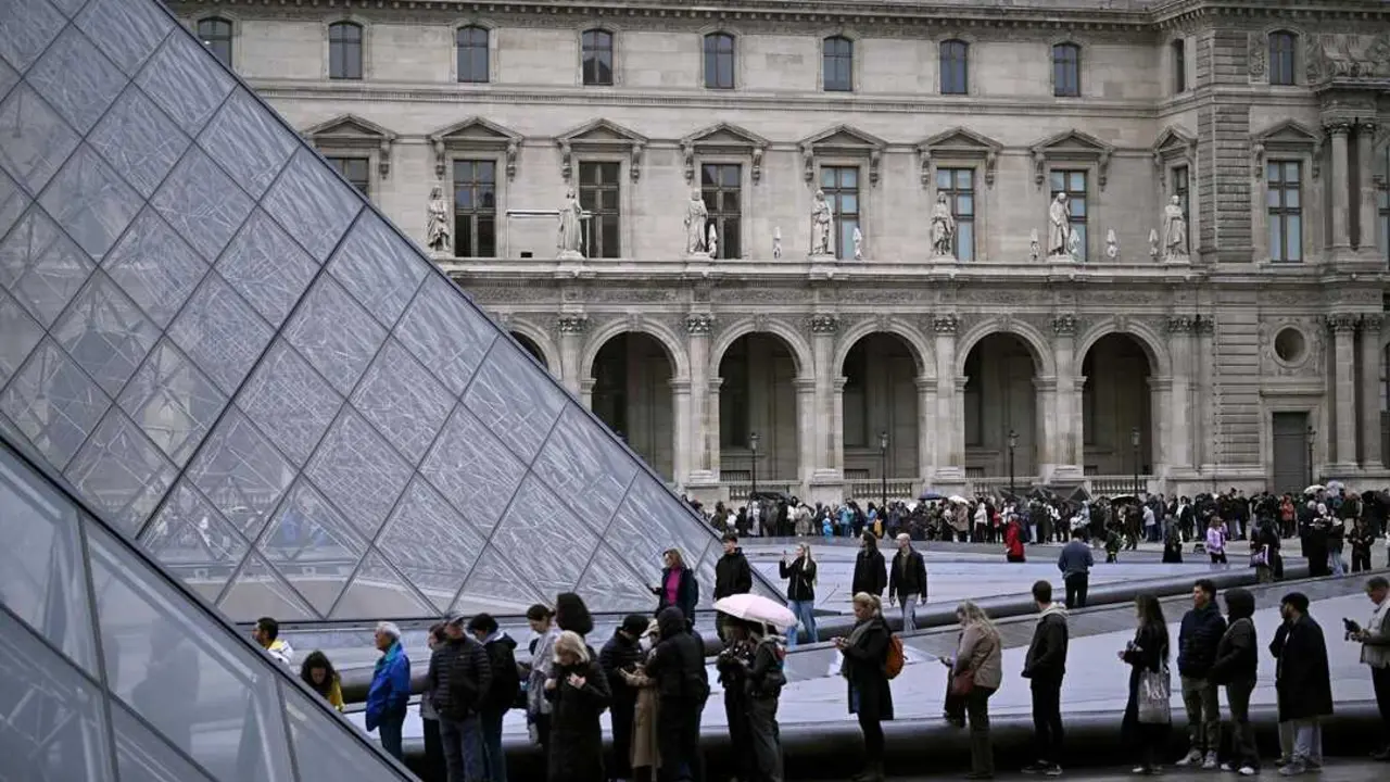 La gente hace cola en el patio de la Pir&aacute;mide del Louvre. / Julien De Rosa