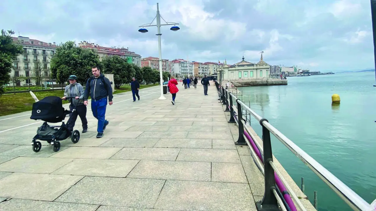 Varias personas recorren el emblem&aacute;tico paseo de la bah&iacute;a de Santander, disfrutando de las vistas y el entorno mar&iacute;timo. / Alerta